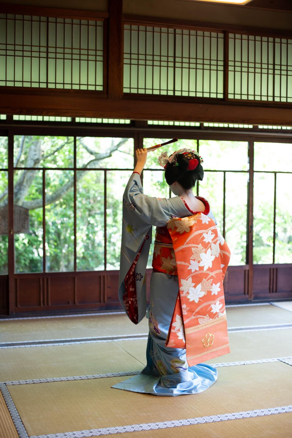 Maiko performing a fan dance in a traditional Kyoto temple room