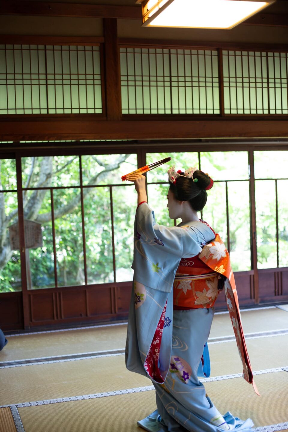 Maiko performing a traditional fan dance in a Kyoto temple room