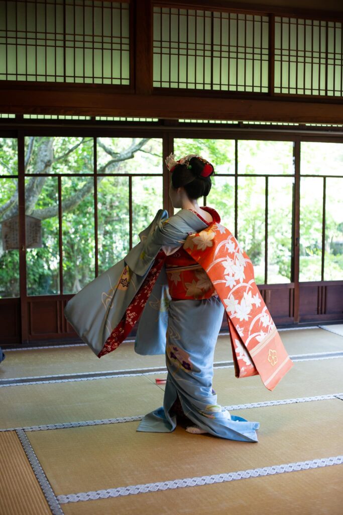Maiko dancing with a flowing kimono sleeve in Kyoto