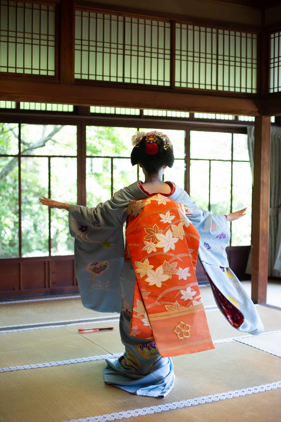 Maiko with arms outstretched performing a traditional Kyoto dance