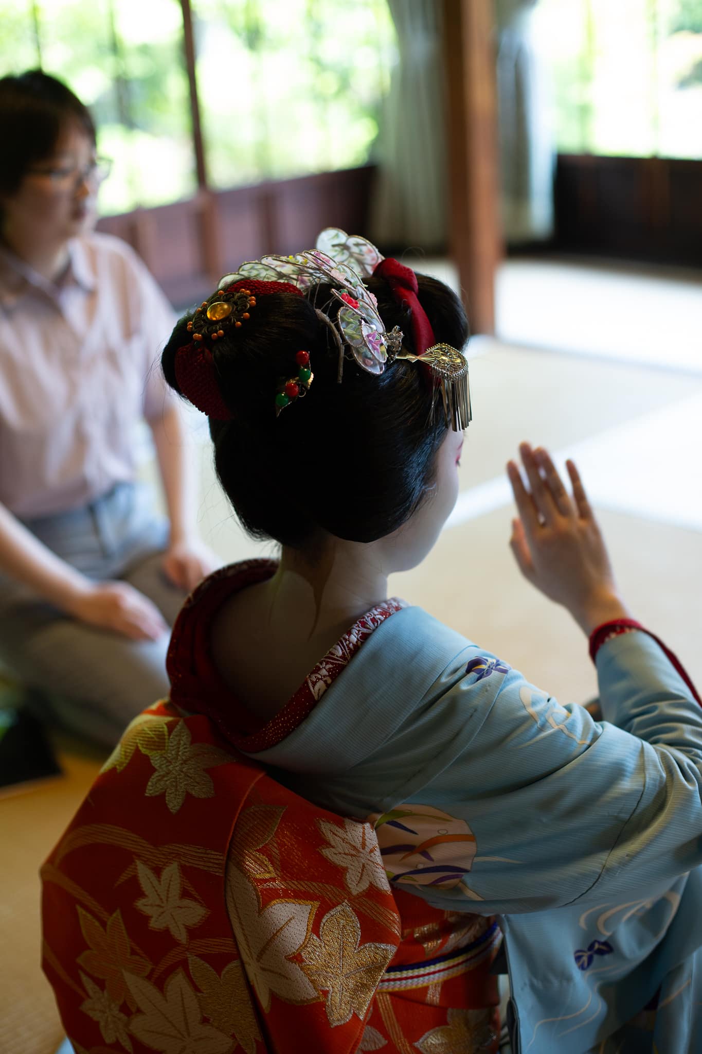 Maiko playing a traditional ozashiki parlor game with a guest in Kyoto