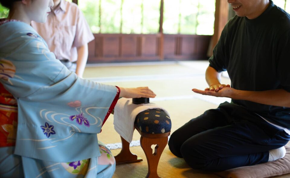 Guest laughing while playing a hand game with a maiko in Kyoto