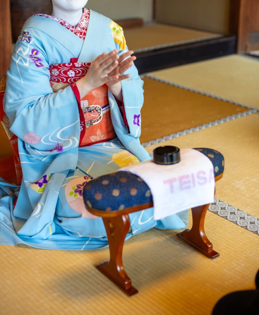 Maiko clapping during a traditional Kyoto parlor game on tatami